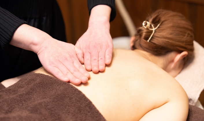 お客様の肌に素手で触れながら微弱電流を流しながら施術